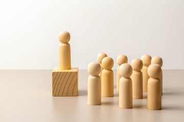 Wooden figure on cube, other figures around on floor