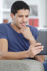 man with digital tablet on the sofa