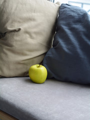 
An apple lies on a soft window sill