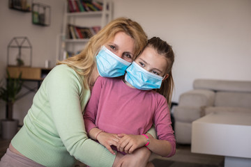 Mother and daughter wear mask as protection against pandemic.