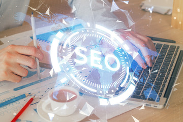 Multi exposure of seo icon with man working on computer on background. Concept of search engine optimization.