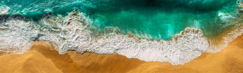 Beautiful sea wave at sunset from a bird's eye view. Beautiful lonely beach at sunset. Aerial view of turquoise ocean waves in Kelingking beach, Nusa penida Island in Bali, Indonesia. Beaches of Bali