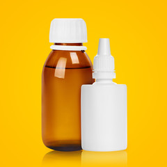 Medical bottle and nasal spray on orange background.