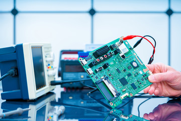 Debugging electronics device. PCB witch microcontroller in electronics laboratory