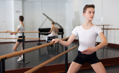 Fototapeta premium Slim young man rehearsing ballet dance in studio