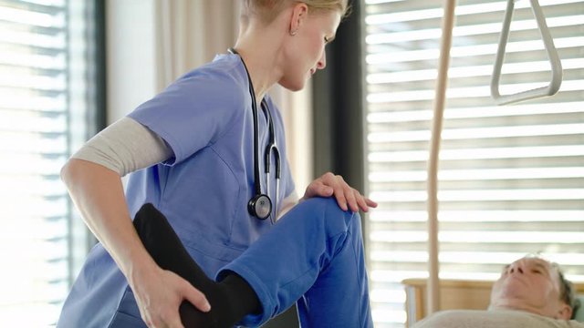 Healthcare worker and paralysed senior patient in hospital, physiotherapy.