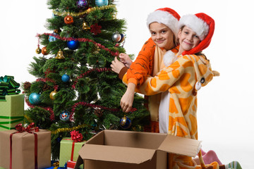 Two girls funny take off toys from a New Year tree