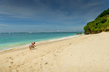 Young couple relax in vacation on the tropical beach. Pandawa beach, Bali, Indonesia.