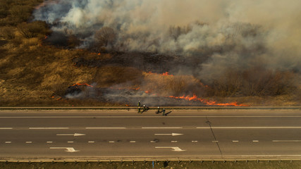 Obraz premium Ukraine, Rivne, 04.04.2020, Massive Fire, Dry Grass Lanes in Fire, Firefighters at Work, Disaster, Ecological Catastrophe