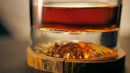 A glass of luxury rum on a wooden coaster