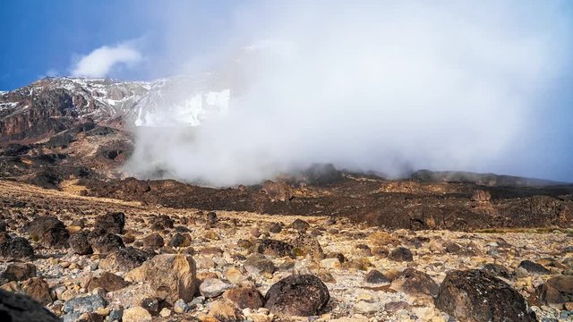 Timelapse view of Kibo with Uhuru Peak (5895m, highest mountain in Africa) at Mount Kilimanjaro, Kilimanjaro National Park. Beautiful landscape with clouds floating over the  volcano.