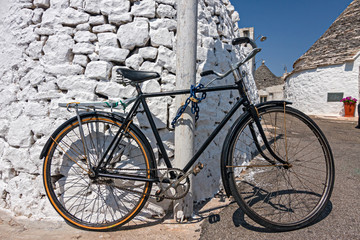 Bicycle leaning against a wall, in Alberobello in Puglia.