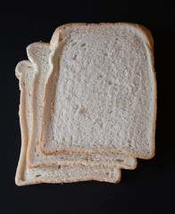 Slices of white bread on a black background