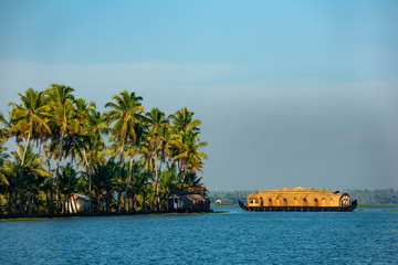 A traditional house boat is anchored on the shores of a fishing lake in Kerala's Backwaters, India.