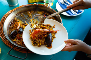 Cook serving seafood paella