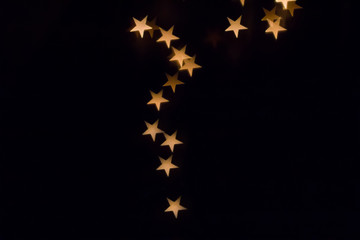 Colorful star bokeh on a dark background, yellow shining star bokeh