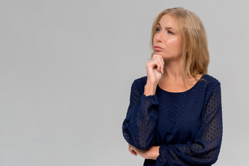 Thoughtful attractive young woman thinking and looking away over white background