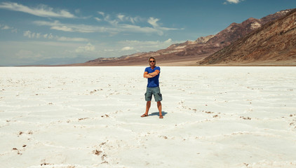 Man standing on salt flatsin sunny desert.