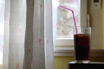 Glass of soda with straw at home. Selective focus.