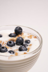 Fresh blueberries in healthy breakfast into a glass with yogurt. Concept of proper nutrition and healthy lifestyle