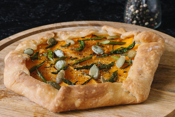 Gallet with pumpkin, asparagus and pumpkin seeds on a black background. Seasonal dishes. Diet Baking