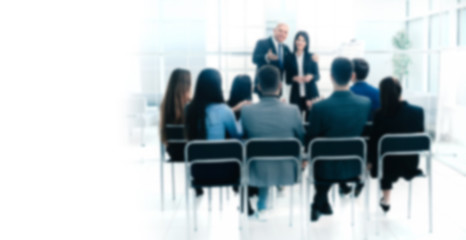 boss representing a young specialist during a work meeting. Background for text with people in blur