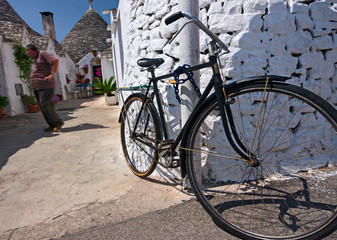 Fototapeta na wymiar Bicycle chained to a wall, in Alberobello in Puglia.