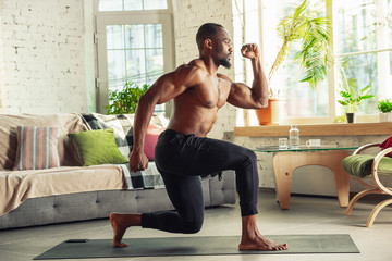 African-american man teaching at home online courses of fitness, aerobic, sporty lifestyle while...