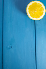 Top view and summer atmosphere of a fresh lemon cut on large blue space