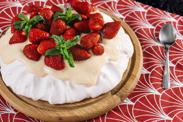 Dessert Anna Pavlova with strawberries on a black background