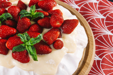 Dessert Anna Pavlova with strawberries on a black background