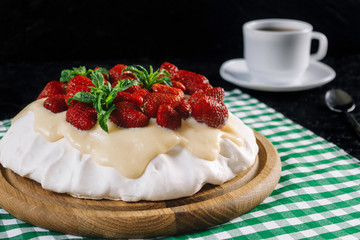 Dessert Anna Pavlova with strawberries on a black background