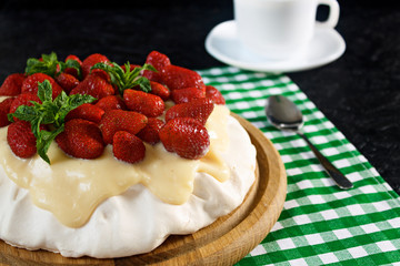 Dessert Anna Pavlova with strawberries on a black background