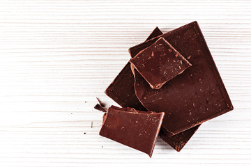 chocolate pieces on white wooden desk with copy space