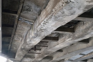 old weathered concrete beam under a bridge