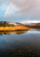 Rainbow Reflection In Calm Lake On Peaceful Morning At Elterwater, Lake District National Park, UK.