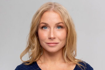 Beautiful woman blonde hair portrait close up studio on gray