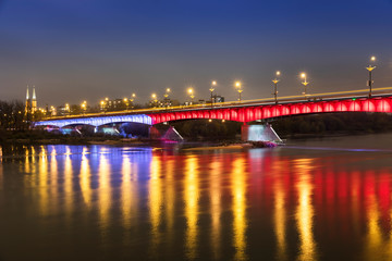 Fototapeta na wymiar Modern illuminated bridge in Warsaw - capital of Poland. Boulevards on the Vistula river.