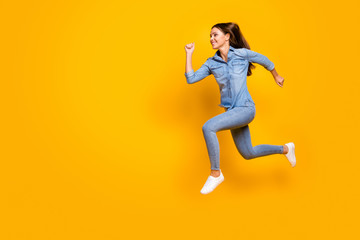 Fototapeta na wymiar Full body profile photo of pretty funky lady jump high up rejoicing good mood rushing speed running final wear casual denim outfit white footwear isolated yellow color background