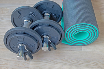 a set of dumbbells and a mat for sports