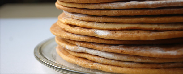 Round baked cake layers stacked on a plate. Homemade cooking honey cake.