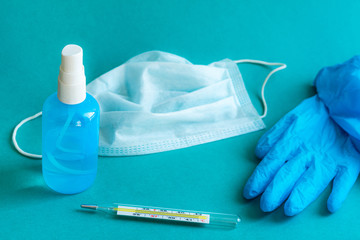 Still life with a medical mask, gloves, antiseptic and thermometer. Concept of treatment of influenza virus or coronavirus.