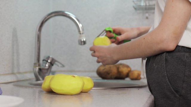 Hands clean peel potato in sink