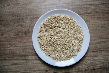 Raw oats in white plate 
