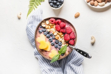 Healthy breakfast banana and blueberry smoothie decorated with fruits in coconut bowl.