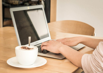 Home office, woman drinks a cup of coffee while working from home