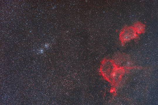Night sky with stars and nebulae. Photo of real space objects through a telescope. Nebula IC 1805 and IC 1871. Constellation Cassiopeia.