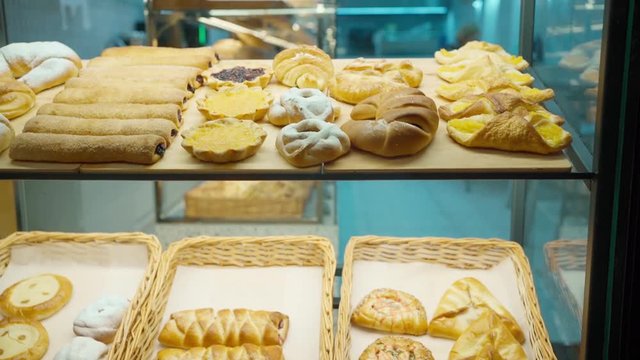 delicious fresh roasted pastmouth-watering pastries and bakery products in wicker baskets through bakery window