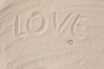 Wedding rings on the sand on the beach