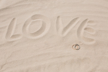 Wedding rings in the sand on the beach